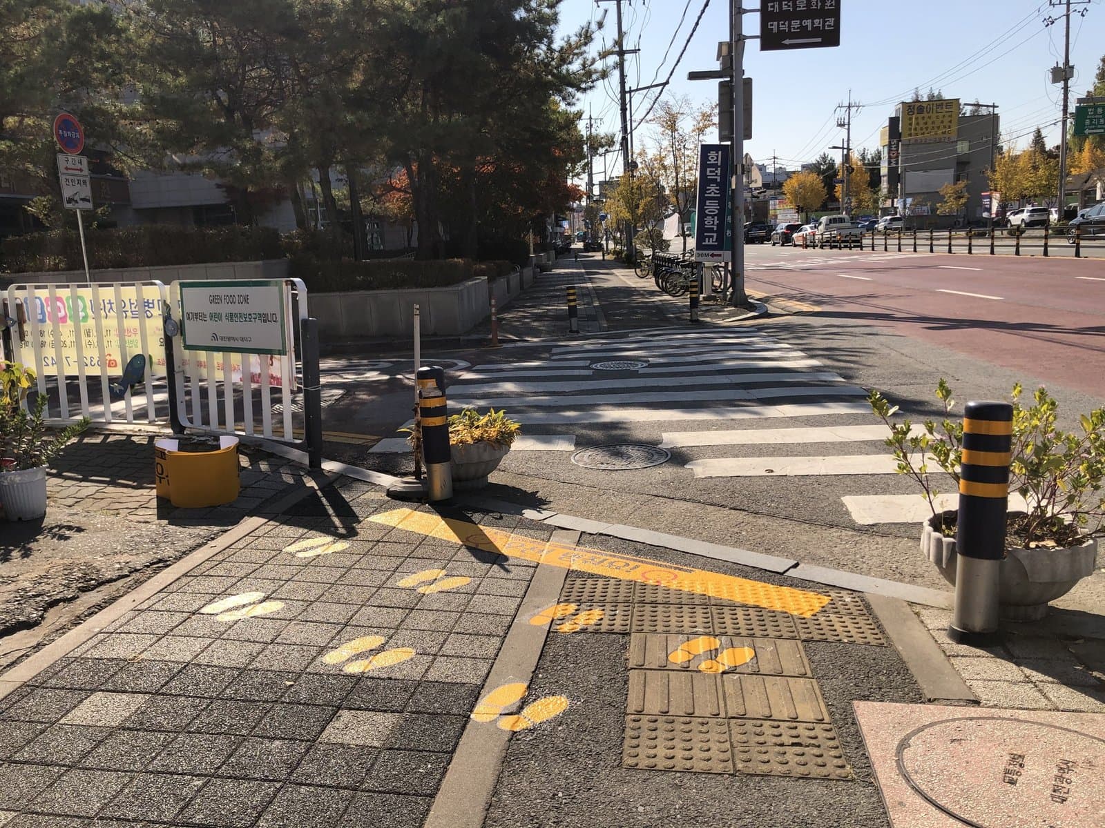 초등학교 앞 횡단 대기 공간에 노란발자국과 정지선 밴드를 부착한 현장