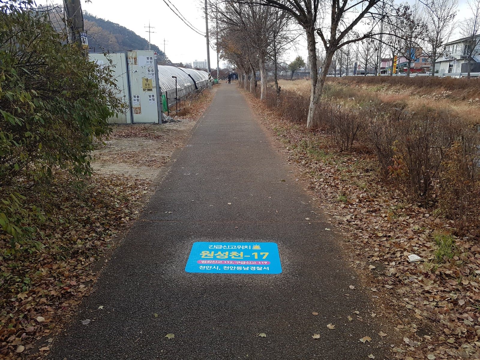 보행로 바닥에 긴급신고 위치 표지를 부착한 산책로